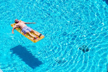 Yüzme havuzunda kırmızı karpuz şilteüzerinde rahatlatıcı kıdemli adam 