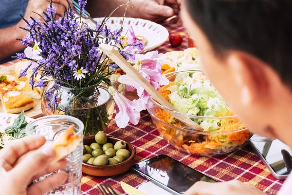 Close up with people friends eating and having fun together having lunch on a table full of food