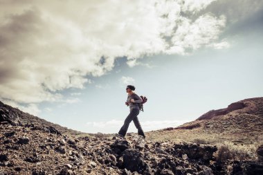 Kurak dağlarda yürüyüş yapan genç aktif kadın.