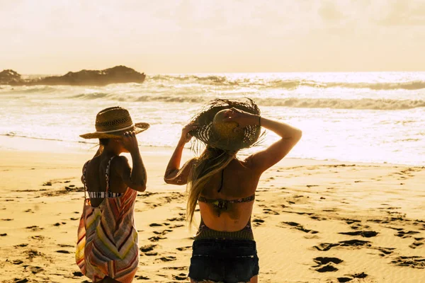 アウトドア休暇のレジャーを楽しんでいる人々とビーチで日没の光 熱帯の景勝地で自然を楽しんでいる数人の女性の友人 黄金の色と自由の概念 — ストック写真