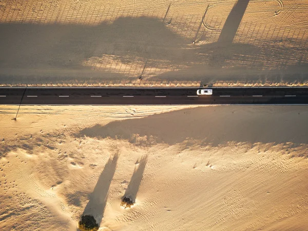 Длинная Дорога Асфальтом Песчаным Пляжем Обеих Сторон — стоковое фото