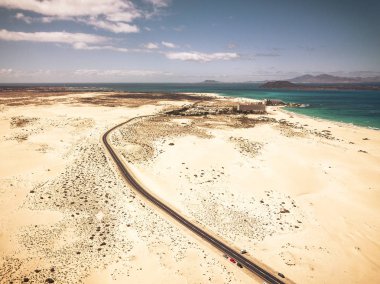 Her iki tarafta çöl ve kum plaj ile uzun karayolu asfalt yol 