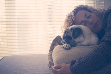 evde kanepeüzerinde en iyi arkadaşı pug ile uyku yetişkin kadın