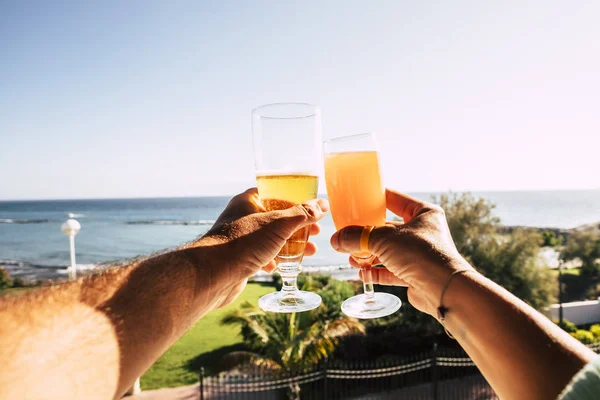 close up of couple enjoy and celebrate summer holiday vacation with beer and fruit cocktail