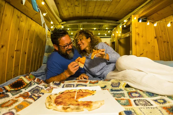 romantic couple eating inside of wooden restored beautiful van