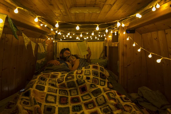 romantic couple sleeping inside of wooden restored beautiful van
