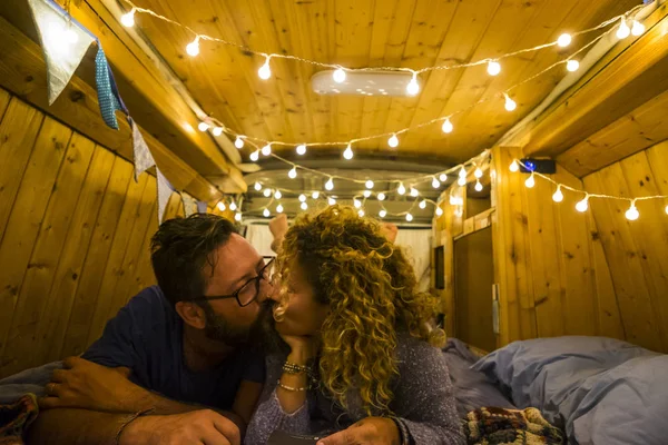 romantic couple kissing inside of wooden restored beautiful van