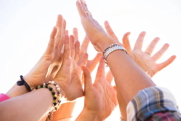close up of group of hands in the air with white background