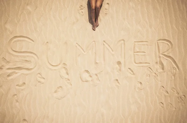 Aerial vertical view of nude woman legs and summer word written on the sand — Stock Image Aerial Vertical View Nude Woman Legs Summer Word Written Sand Royalty Free Stock Photos