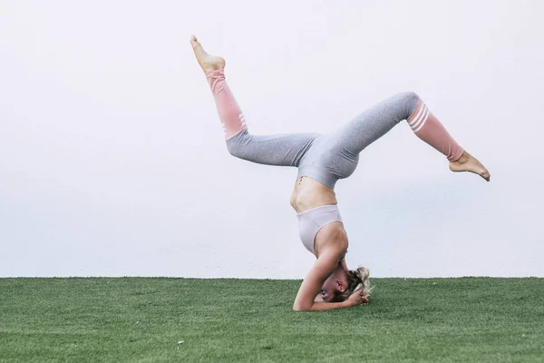 Akrobatik yoga açık hava spor aktivitesi ve genç atlet kadınla sağIık konsepti ters pozisyonda.