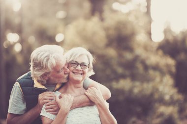 Bir çift mutlu ve neşeli son sınıf öğrencisi Sevgi ve gülümsemeyle sarılır 