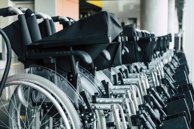 Havalimanında ya da istasyonda park halindeki tekerlekli sandalyeler çeşitlilik için insanlar uçakla seyahat etmelerine yardım edebilir.