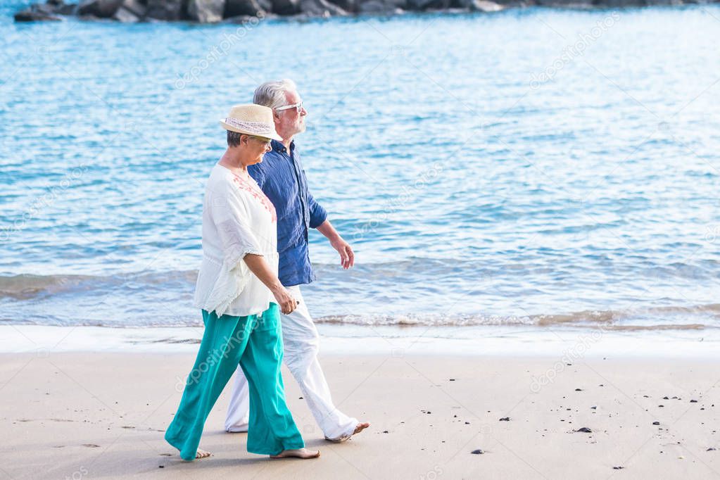 couple of people seniors walking at the beach 