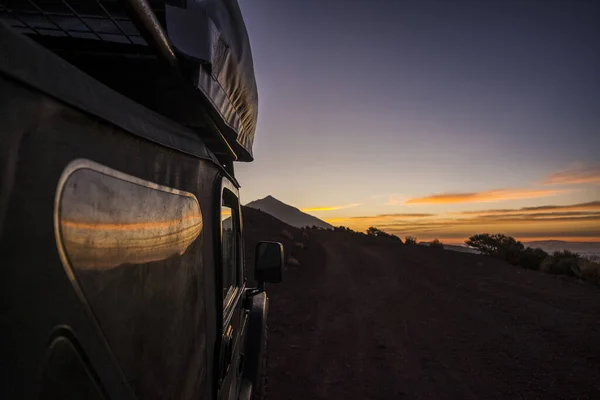 日落背景下的山中黑色轿车的近景 — 图库照片