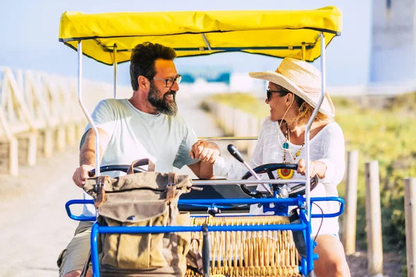 Adult cheerful people couple having fun outdoor with vacation double bike together