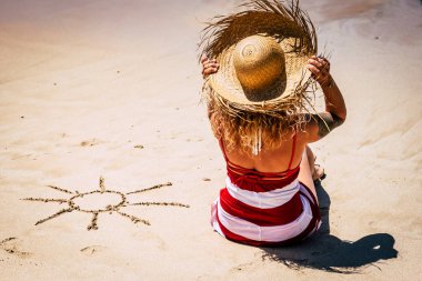 Plajdaki insanlarla güneş ve yaz tatili konsepti ve turist şapkalı bir kadın günün tadını çıkarıyor ve açık hava aktivitelerini rahatlatıyor.