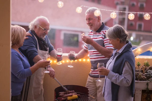 幸せな高齢者の友人のグループは屋外テラスでバーベキューナイトを一緒に楽しむ — ストック写真