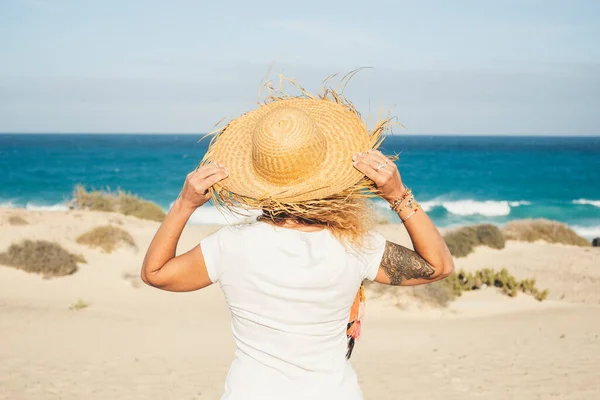 头戴旅游帽的女人欣赏海滩 望着蓝天蓝天蓝天的大海 — 图库照片