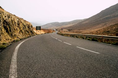 Kara asfalt uzun bir yolun zemin manzarası - seyahat ve varış yeri arayışı - vadi ve dağlar manzarası güzel