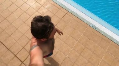 Neşeli olgun bir adam havuza atlıyor.