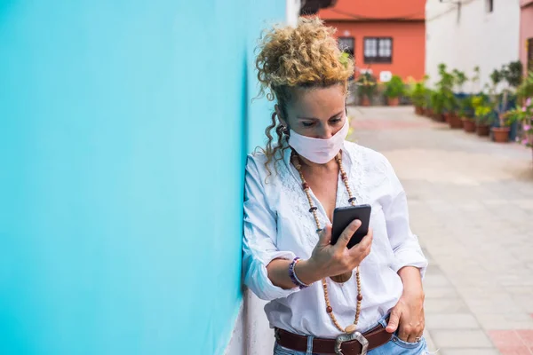 Γυναίκα Εξωτερική Στο Δρόμο Χρησιμοποιώντας Σύγχρονο Τηλέφωνο Και Φορώντας Μάσκα — Φωτογραφία Αρχείου