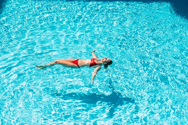 美丽的女人在蓝色的游泳池边游泳 享受暑假和健康的生活方式 — 图库照片