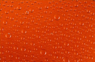 temiz su damla şeffaf turuncu renkli bir arka plan üzerinde ışık yansıması ile