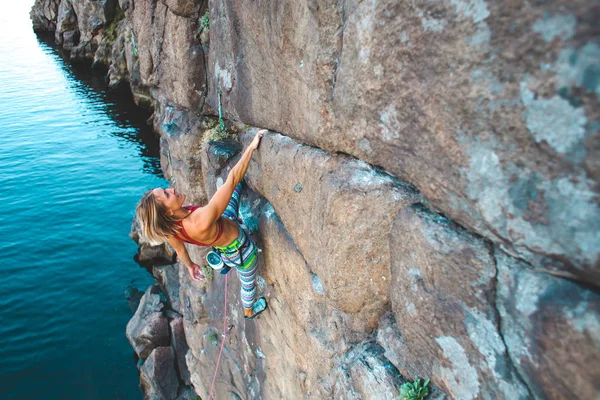 水の上のクライマー 女性は 岩を登っていきます 自然の地形でのトレーニング 極端なスポーツ 海岸沿いに登山ルート — ストック写真