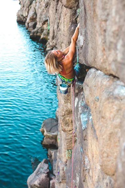 水の上のクライマー 女性は 岩を登っていきます 自然の地形でのトレーニング 極端なスポーツ 海岸沿いに登山ルート — ストック写真