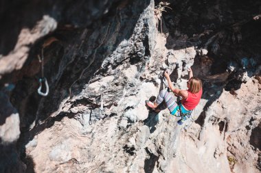 Bir kadın rock tırmanıyor. Doğada tırmanma. Fitness açık havada. Aktif yaşam tarzı. Ekstrem Sporlar. Doğal bir rahatlama atlet trenlerde. Türkiye'de dağcılık.