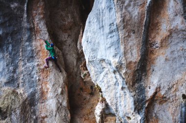 Bir kaya tırmanışçısı. Kız bir tırmanış yapıyor. Doğada spor. Açık havada aktif yaşam tarzı ve spor. Aşırı bir hobi. Cesur kadın..