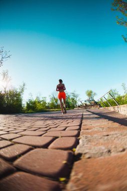 Parkta sabah dürtmek. Kız sokak şehir çalışır. Şafakta eğitim. Bir kadın kaldırımda yürüyor.
