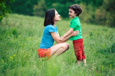 Çocuk annesi doğa ile iletişim kurar. Bir kadın oğluna dinler. Çayır ile bebek ile yürümek. Çocuk annesiyle konuşuyor. Bir kadın bir çocuk sarılma. 