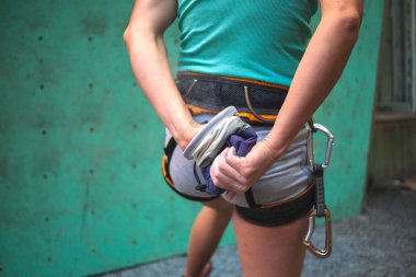 Dağcı rota tırmanmaya hazırlanıyor. Kadın elleriyle magnezyum losyonları. Çıkış için hazırlık. Magnesia sporcunun belden için çanta. Bacak ve kalça eğitimli bir kız.