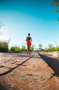 Parkta sabah dürtmek. Kız sokak şehir çalışır. Şafakta eğitim. Bir kadın kaldırımda yürüyor.