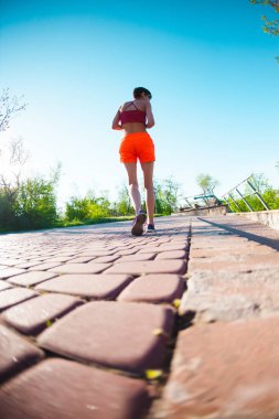 Parkta sabah dürtmek. Kız sokak şehir çalışır. Şafakta eğitim. Bir kadın kaldırımda yürüyor.