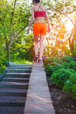 Kız parapet yürüyor. Bir kadın parkta spor yapıyor. Sabah cityscape.