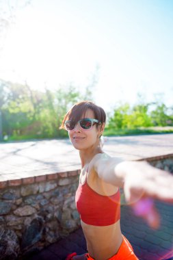 Kız sabah yogada devreye girer. Bir kadın parkta eğitiyor. Germe. Aktif yaşam tarzı.