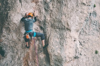 Kasklı bir adam kayaya tırmanıyor. Doğaya tırmanmak. Spor salonu açık havada. Aktif yaşam tarzı. Ekstrem sporlar. Sporcu doğal bir rahatlama ile antrenman yapar. Resimli bir yerde eğitim görüyorum. Türkiye 'de tırmanış.