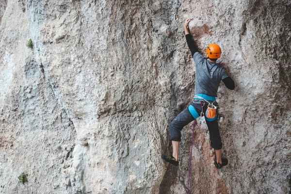 ヘルメットの男が岩に登る 自然の中でクライミング 屋外でフィットネス 積極的なライフスタイル 極端なスポーツだ アスリートは自然救済の訓練を受ける トルコのロッククライミング — ストック写真