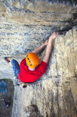 Tırmanıcı bir kask içinde yukarı tırmanıyor.