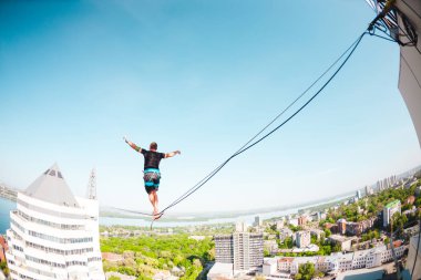 İki bina arasında uzanan bir çizgi boyunca bir adam girer. Aşırı eğlence. Yükseklik korkusu. Adam şehrin üzerinde Dengeleme.