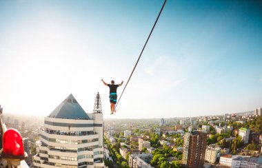 İki bina arasında uzanan bir çizgi boyunca bir adam girer. Aşırı eğlence. Yükseklik korkusu. Adam şehrin üzerinde Dengeleme.