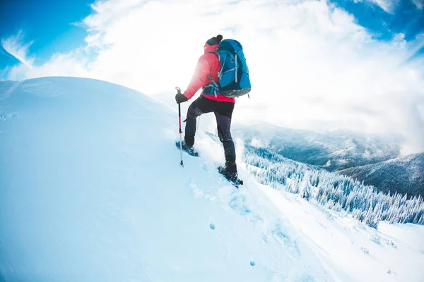 一个雪的人在山里过冬 一个登山者拄着拐杖走过雪地 冬天上升 美丽的天空与云彩 — 图库照片