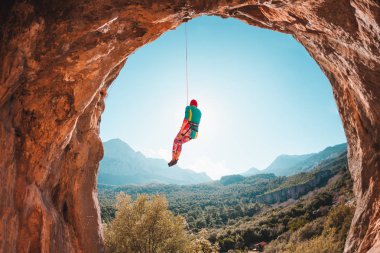 Tırmanıcı bir ipte asılı duruyor. Kızı aşağı gider. Türkiye'de dağcılık. Dağ manzarası. Bir kadın doğa sporları devreye girer. Rock bir kemer şeklinde. Mağaradaki tırmanma rotası.