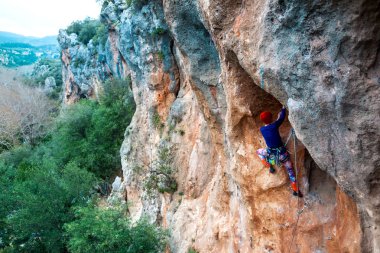 Bir kaya tırmanışçısı. Kız bir tırmanış yapıyor. Doğada spor. Açık havada aktif yaşam tarzı ve spor. Aşırı bir hobi. Cesur kadın..