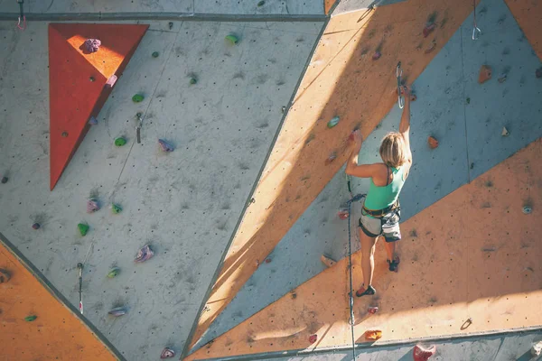 Yapay bir rahatlama dağcı trenlerde. Bir kadın bir tırmanma yol sokak tırmanma duvarı üzerinde tırmanıyor. Eğitim salonunda.