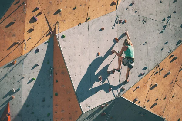 登山者用人工的浮雕训练 一个女人爬上一条爬在爬墙上的登山路线 训练在大厅里 — 图库照片