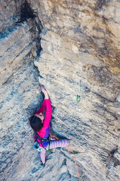 女の子は 岩を登っていきます 女性は克服困難な登山ルートです 岩に岩登り スポーツ アウトドアをやってください — ストック写真