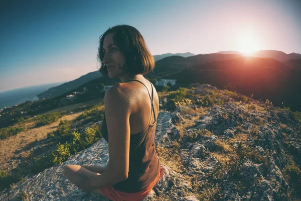 Μια Κοπέλα Κάθεται Στην Κορυφή Ενός Βουνού Στο Ηλιοβασίλεμα Μια — Φωτογραφία Αρχείου